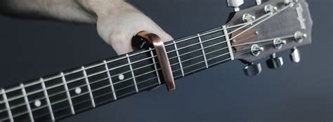 What does a guitar capo do, and why does it make the strings whisper secrets to the frets?